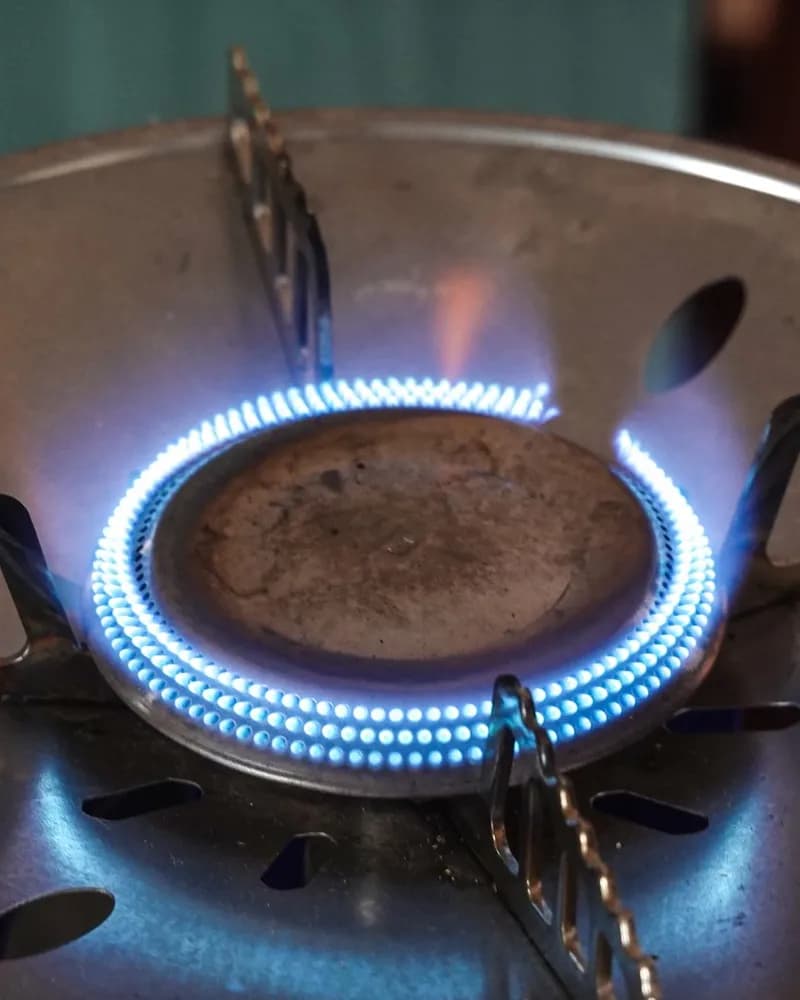Close-up of a lit gas burner with blue flames